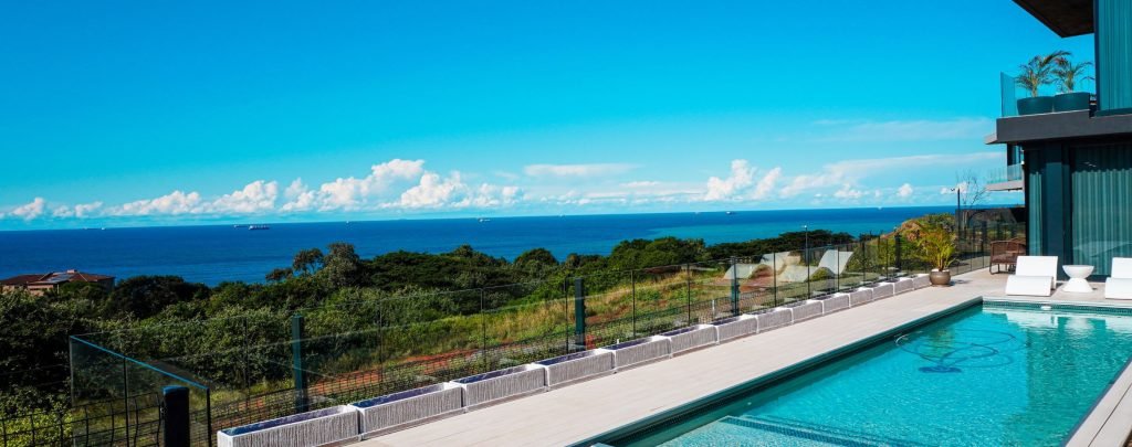 designer pool covers A pool with a view of the ocean and pool covers.